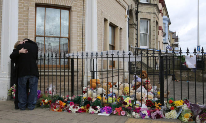 Craig McLelland, the former partner of Fiona Anderson, is comforted by his mother Amanda McLelland, as they view tributes outside her flat in Lowestoft.