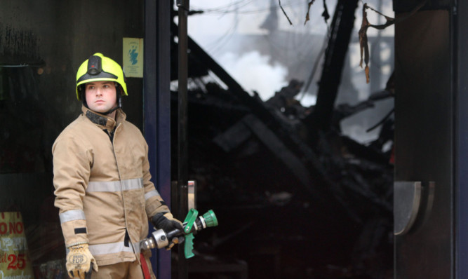 A firefighter in the shell of the Christmas Shop, which was the scene of a massive blaze in December.