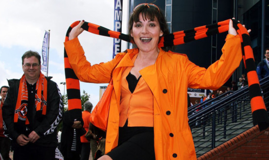 photo shows TV presenter Lorraine Kelly dressed in tangerine and black clothing and carrying a tangerine and black Dundee United scarf outside Hampden Park football stadium.