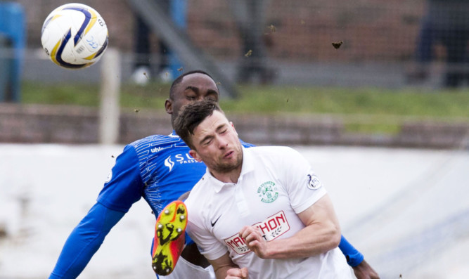 Kudus Oyenuga battles Hibs Lewis Stevenson for the ball.