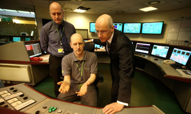 Deputy First Minister John Swinney, right, talks to staff in the control room during a visit to Longannet power station in Fife.