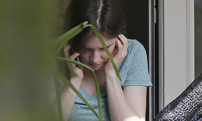 Amanda Knox talks on the phone as news of her acquittal emerged on Friday.