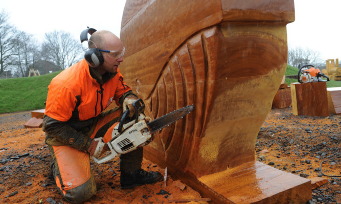 Jonny Chainsaw crafting the whale out of the block of hardwood.