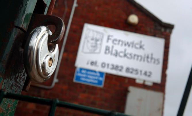 A padlock hangs on the gate of blacksmiths firm Fenwick.