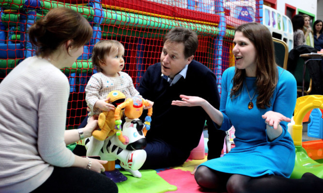 Deputy Prime Minister Nick Clegg and East Dunbartonshires Liberal Democrat MP Jo Swinson play with 14-month-old Sophia ODriscoll from Anniesland during a visit to a nursery.