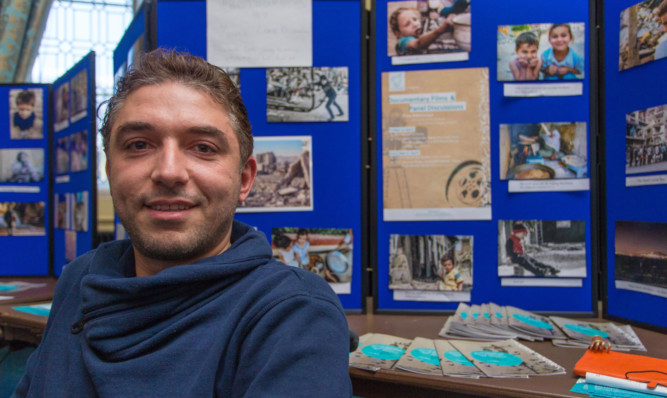 Haian Dukhan, one of the organisers, in front of an exhibition at the Stand for Syria festival.