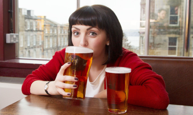 Glass act: Dusas Zuchaela Smylie tries out the unions new two-pint glass, shown alongside a pint glass.
