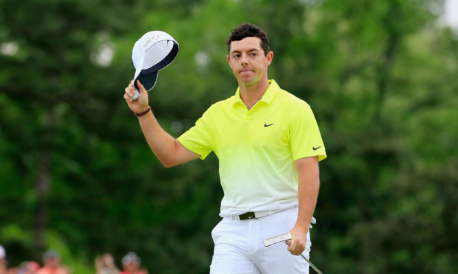 Rory McIlroy waves to the gallery on the 18th green.