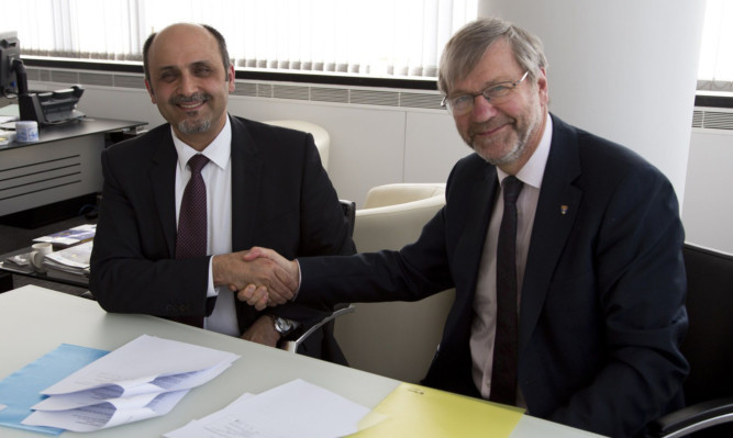 Dr Faisal M Al-Mohanna Abaalkhail from the Saudi Arabian cultural attache shakes hands on the agreement with Professor Pete Downes, principal and vice-chancellor of Dundee University.