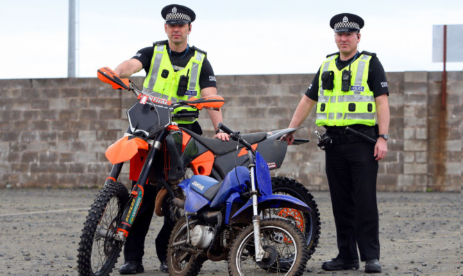 PC Mark McCulloch and PC Steven Black with two off-road bikes which have been confiscated.