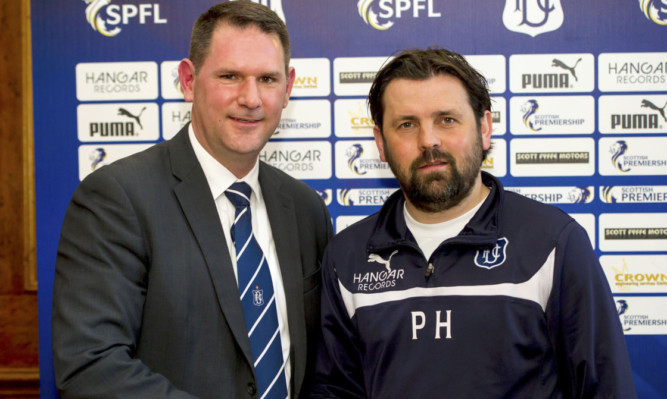 John Nelms (left) joins manager Paul Hartley as he signs a new three-year contract.