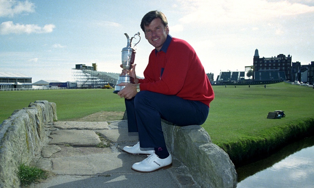 Nick Faldo sitting on the Swilkan Bridge on the 18th fairway of the St. Andrew's Golf Course with the Open Trophy.