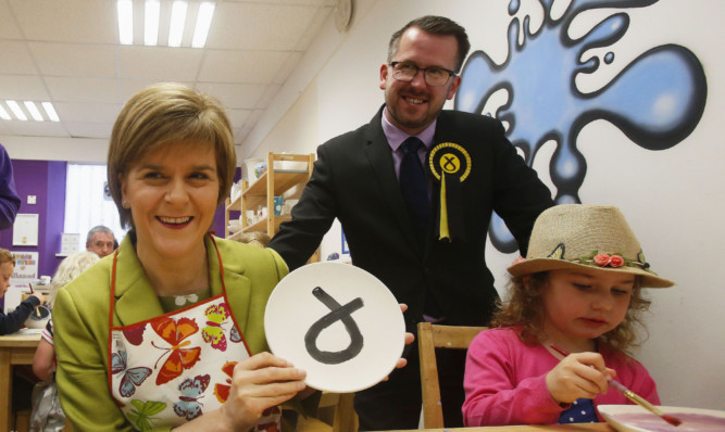 Nicola Sturgeon with three-year-old Kitty MacDonald and SNP candidate for the Glasgow South constituency Stewart McDonald during a visit to Glazed, a ceramic painting studio in Glasgow.