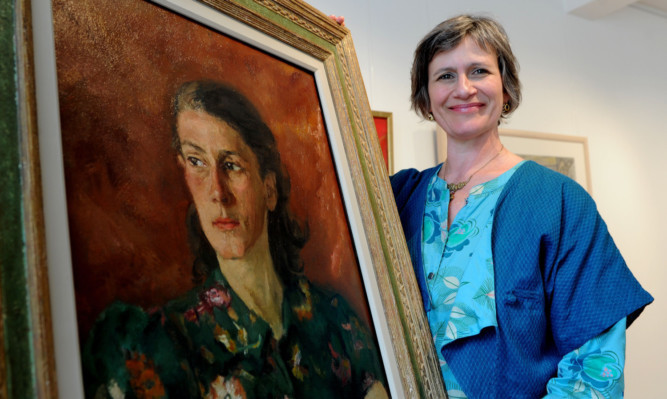 Carolyn Strobos with the painting of her mother, a member of the Dutch resistance during the Second World War.
