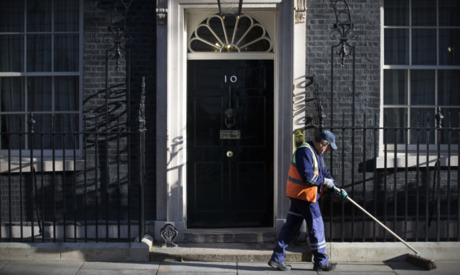 A street sweeper cleans the pavement in front of 10 Downing Street in the run-up to what is predicted to be Britain's closest national election in decades.