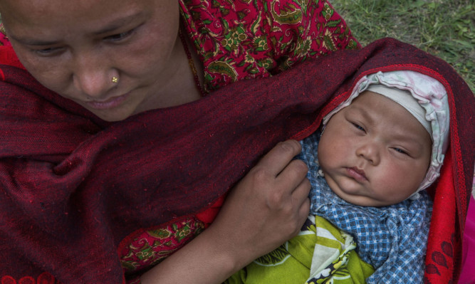 A mother holds her child in an evacuation area set up by the authorities in Kathmandu.