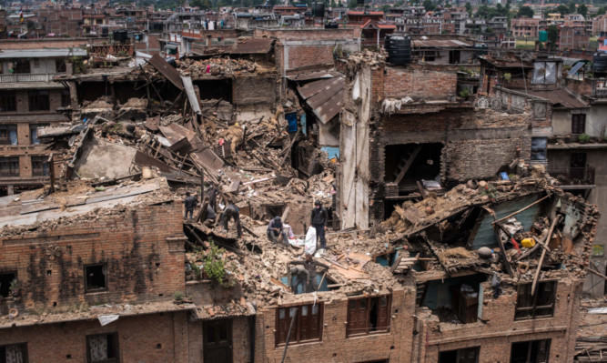 Nepalese victims of the earthquake search for their belongings among debris of their homes in Bhaktapur.