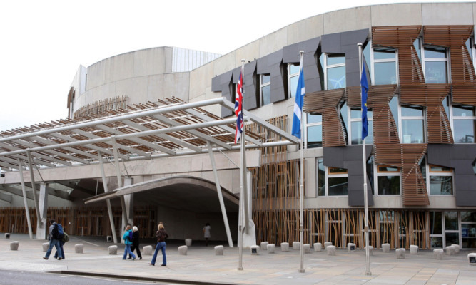 The protester was escorted from the Scottish Parliament after disrupting the debate in the chamber.