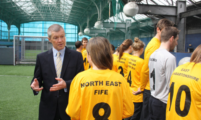 Scottish Liberal Democrats leader Willie Rennie giving a team talk to footballers wearing customised strips for each constituency the party currently holds.