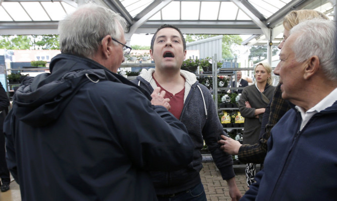 A SNP heckler shouts during an election rally by Prime Minister David Cameron at Squires garden centre in London.