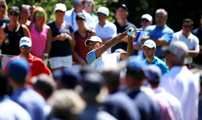 Former world No 1 Tiger Woods is the centre of attention as he plays his tee shot on the eighth at Sawgrass.