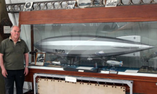 Derek Brown with a model of the R100 airship that he helped to disassemble.