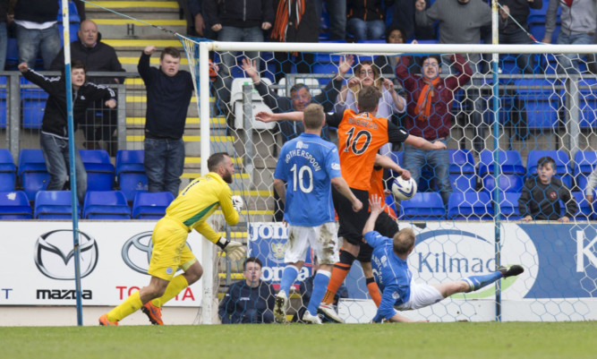 Dundee United's John Rankin (blocked) heads home to put his side ahead.