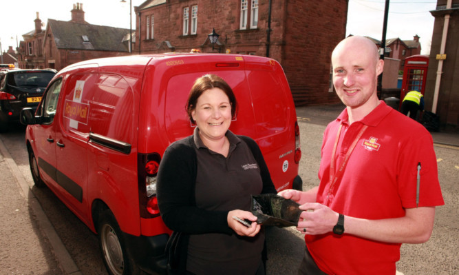 Lorraine Simpson is delighted to receive her lost purse from postman Lewis Armstrong.