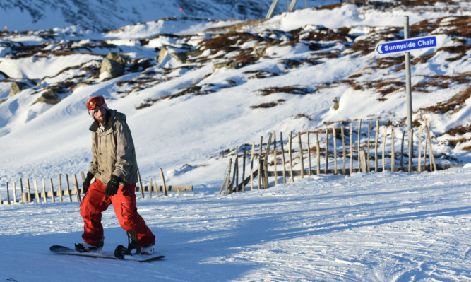 A snowboarder takes to the slopes at the Glenshee Ski Centre.