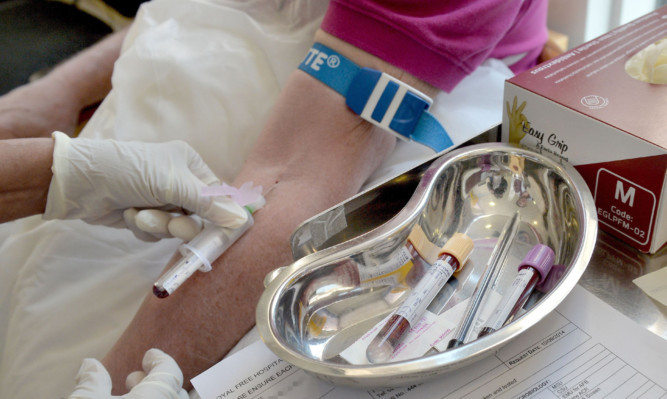 A nurse taking blood.