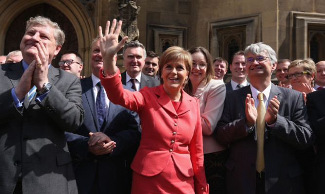 All smiles  but for how long? Nicola Sturgeon and her new intake of SNP MPs outside Westminster.