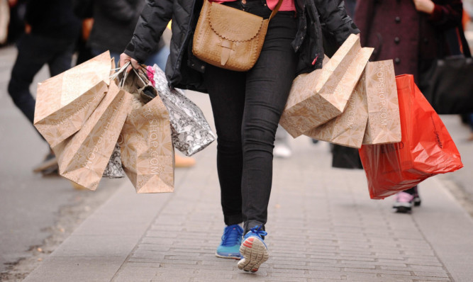 File photo dated 6/12/11 of a shopper carrying shopping bags. High street sales dropped by 2.2% last month in an "underwhelming" Christmas for many retailers, according to a report. ... High street sales ... 06-01-2014 ... London ... UK ... Photo credit should read: Dominic Lipinski/PA Wire. Unique Reference No. 18604411 ... Issue date: Monday January 6, 2014. Figures from accountancy firm BDO showed the sales surge hoped for by many shops failed to materialise in the crucial trading period, with like-for-like sales - excluding online trade - dropping by as much as 6.7% in the week to December 22. See PA story ECONOMY Retail. Photo credit should read: Dominic Lipinski/PA Wire