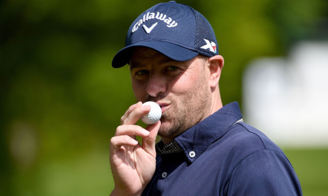 A kiss but no car keys: Craig Lee celebrates his hole-in-one at Wentworth yesterday.