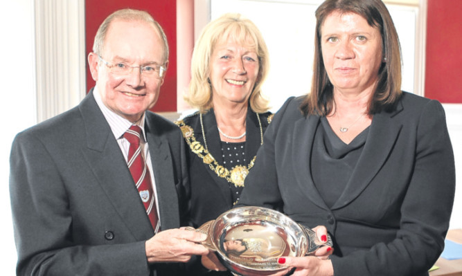Arbroath FC chairman John Christison, honoured with a civic reception to recognise his loyal commitment to the club, receives a quaich from Red Lichties director Anne McKeown with Angus Provost Helen Oswald looking on.