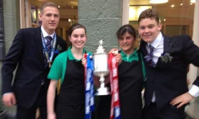 Staff pose with Inverness CT's cup-winning players as they stop off in Aucterarder.