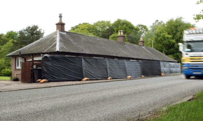 Properties on the A92 near Arbroath wrapped in tarpaulin ahead of work being carried out on the road.