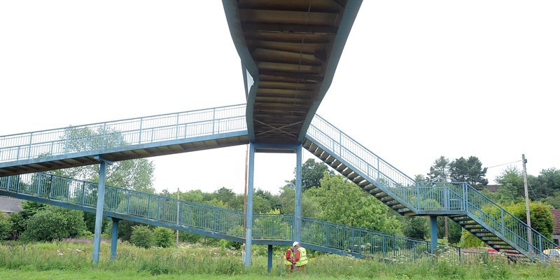 Workmen inspect the foot bridge over the A911 that was hit by a lorry