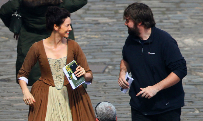 Caitriona Balfe, who plays time-travelling nurse Claire Randall in the hit show, shares a joke with a crew member during filming for series two.