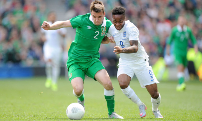 Seamus Coleman battles for possession with England's Raheem Sterling.
