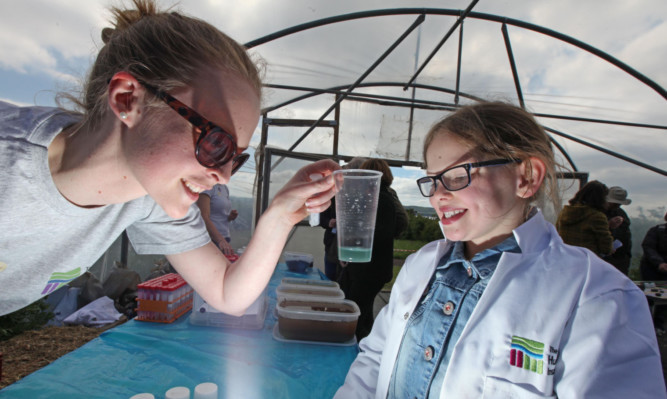 Maisie McCrimmon tries out the crazy chemistry area with a JHI scientist.