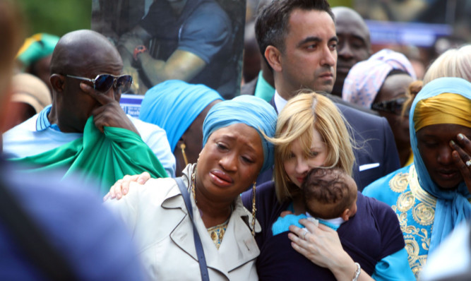 Shekus partner Collette Bell and their son Isaac with mourners at his funeral.