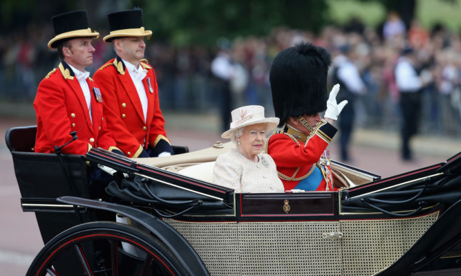 The Queen and Prince Philip travel in the royal carriage during the Trooping The Colour.