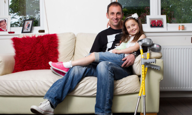 Summer Wroniecki, here with father Chris, was thrown from a giant inflatable slide last weekend.