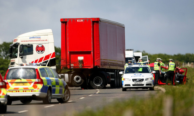 Our picture shows police beside the damaged car and lorry on the A92.