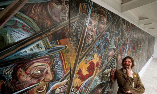 Artist Chris Rutterford poses with a mural that he created for the courtyard of the Battle of Bannockburn centre ahead of the 701st anniversary.