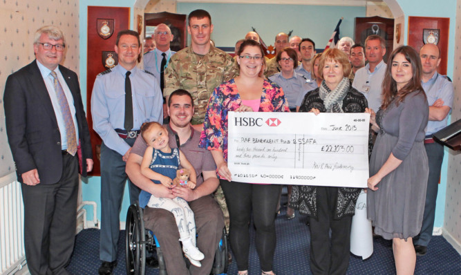 Kevin Ogilvie and his family present the cheque at RAF Honington.