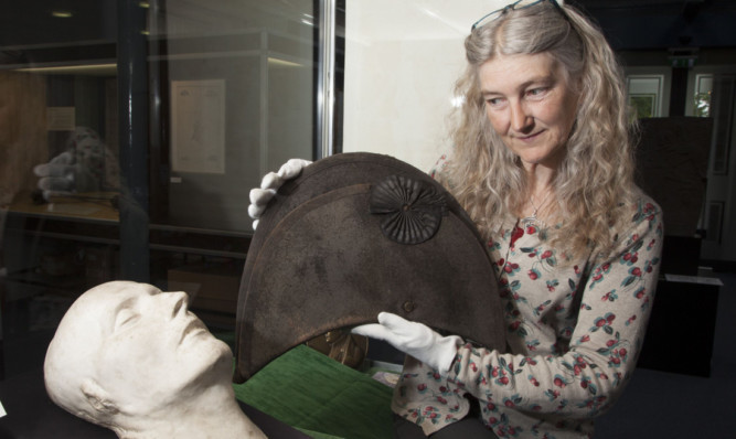 Museum assistant Linda Fraser with the mask and hat.