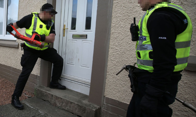 Officers force entry into a property in Cowdenbeath.