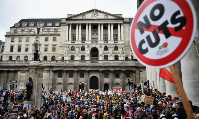 Protestors march through central London during a demonstration against austerity and spending cuts.