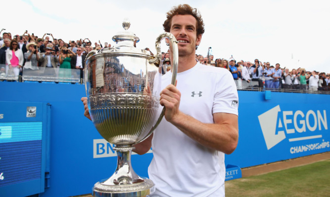 Andy Murray celebrates victory with the trophy after winning his fourth Queen's title.